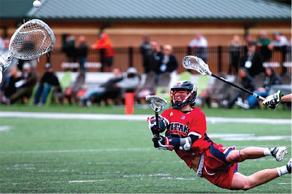 UDM team member catching lacrosse ball